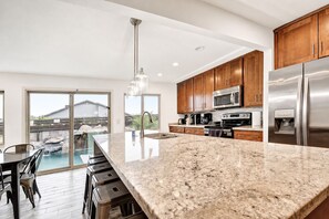 A modern kitchen with granite countertops, stainless steel appliances, and wooden cabinets.