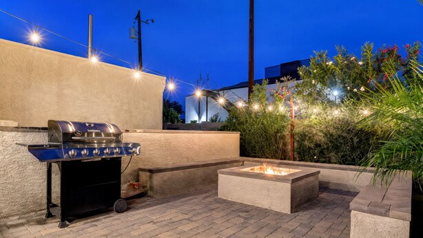 Un patio al aire libre con una parrilla y un brasero.