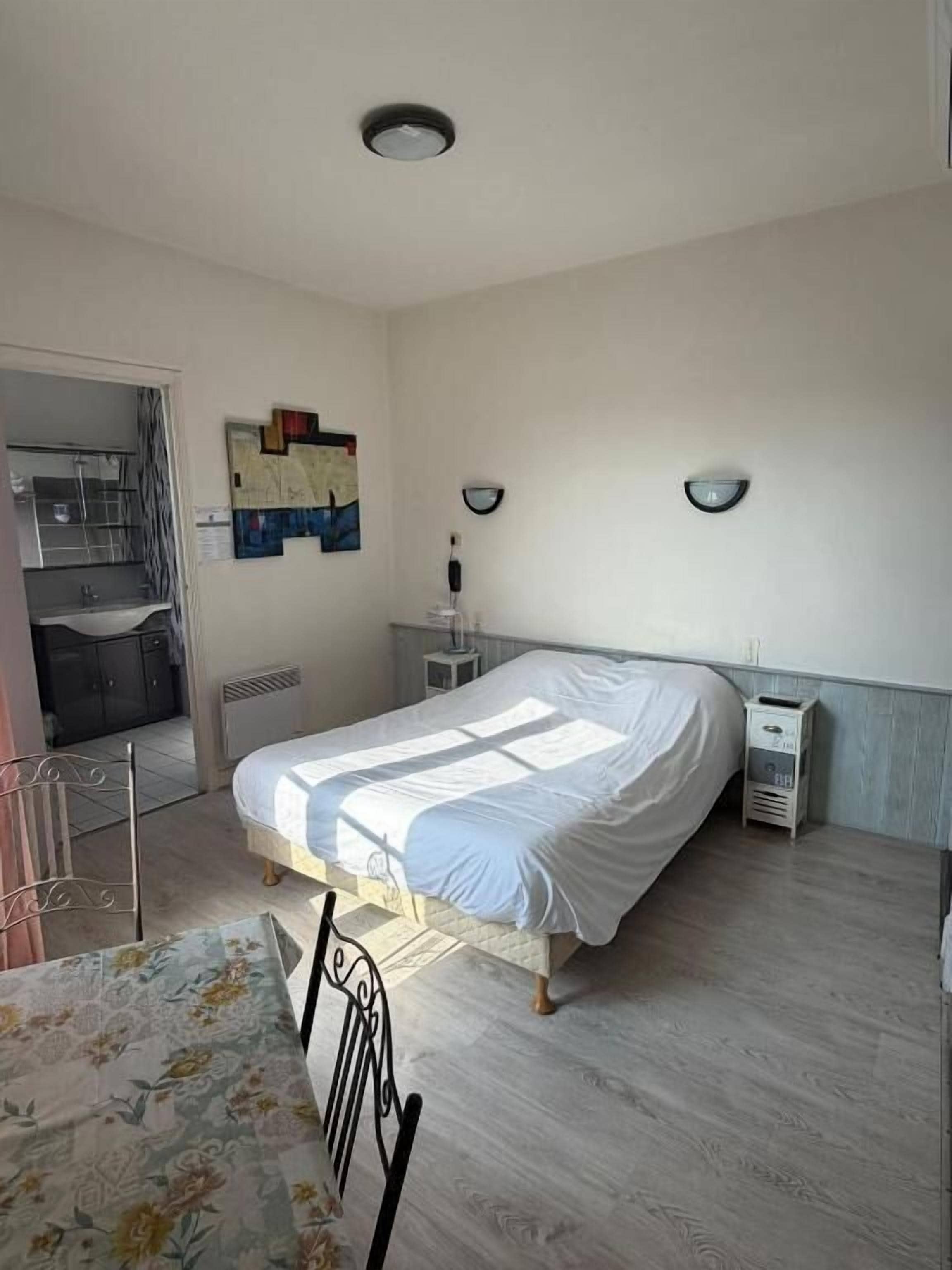 Una camera da letto con un letto, comodini, un termosifone e una finestra.