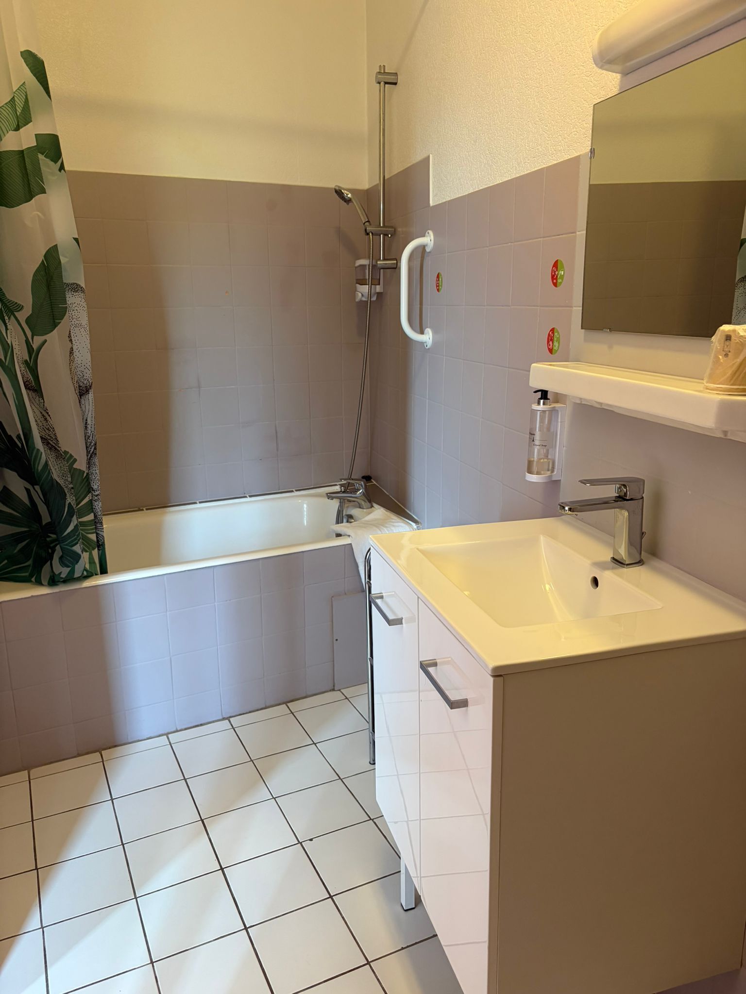 A bathroom with a bathtub, a sink, and a mirror.