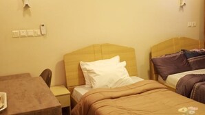 A hotel room with a single bed, a wooden nightstand, a desk, and a chair. - Luxury stylish premium Home in Prime Location, Exceptional Hospitality (Abuja)