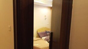 A hotel room with a bed, a headboard, and a light fixture on the ceiling. - Luxury stylish premium Home in Prime Location, Exceptional Hospitality (Abuja)