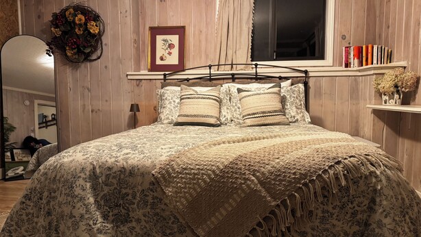A bedroom with a bed, a window, a shelf with books, and a mirror. - Quintessential Berkshire Escape - Artist Home, Tucked Away in Nature (Otis)