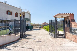 A gated residential area with paved pathways and parked vehicles. - A 5-minute drive from Pompeii: a cozy family apartment with free parking. (Santa Maria la Carità)