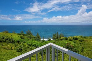 A view from a balcony overlooking a coastal landscape with a clear sky and ocean. - Moana Kai by Gather - Top-Floor Corner w/ Unobstructed Ocean Views & Lanai (Princeville)