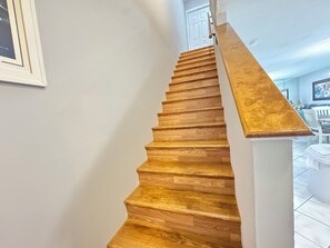 A wooden staircase with a white handrail leading to a room with a white door. -     Your Perfect Beach Escape Sleeps 8 (Panama City Beach)