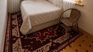 A bedroom with a bed, a chair, a window with a view, and a ceiling light fixture. - Spacious Forest Guesthouse in Vanadzor (Vanadzor)