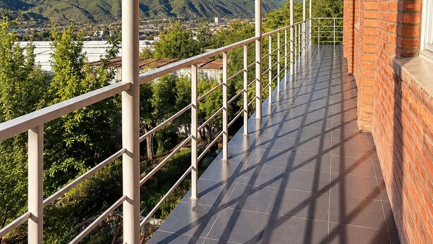 A covered balcony with a view of mountains and a town. - Spacious Forest Guesthouse in Vanadzor (Vanadzor)