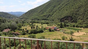 Paisaje rural con un valle, casas y una montaña.