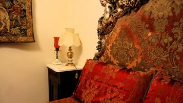 Une chambre avec un lit, une table de chevet, une lampe et un tableau accroché au mur.