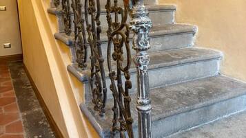 Un escalier orné de rampes en métal ouvragé et doté d’une main courante en bois.