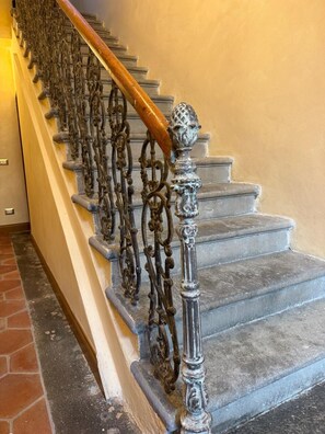 A staircase with ornate metal railings and a wooden handrail.