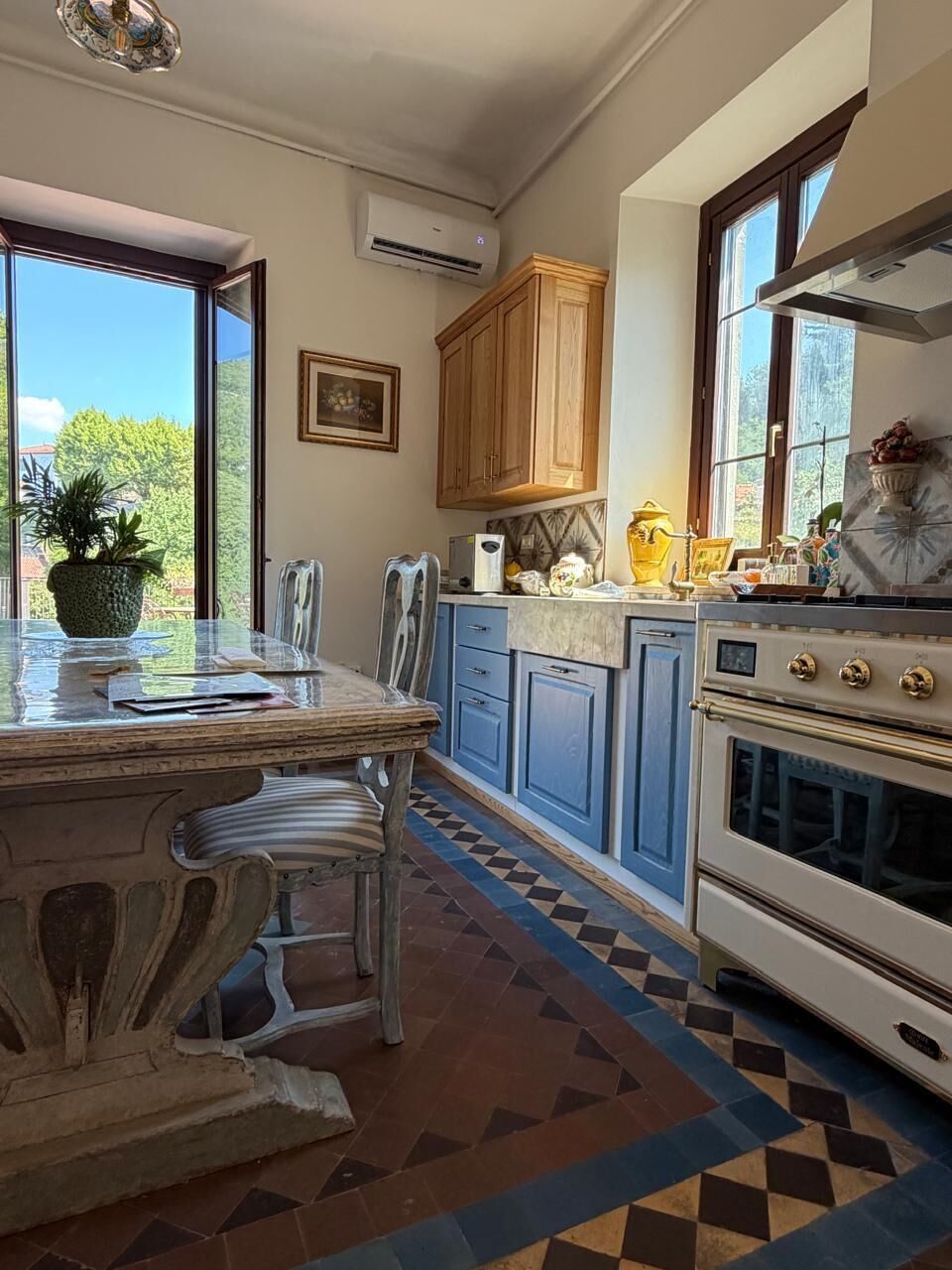 A kitchen with a large island, wooden cabinets, and a tiled floor.