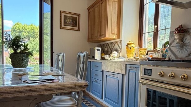 Una cocina con una isla grande, armarios de madera y piso de baldosas.