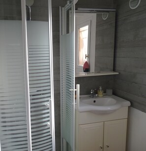 A bathroom with a shower, a sink, and a mirror. - Maisonnette de 3 chambres, dans un village vacances à Gujan-Mestras. (Gujan-Mestras)