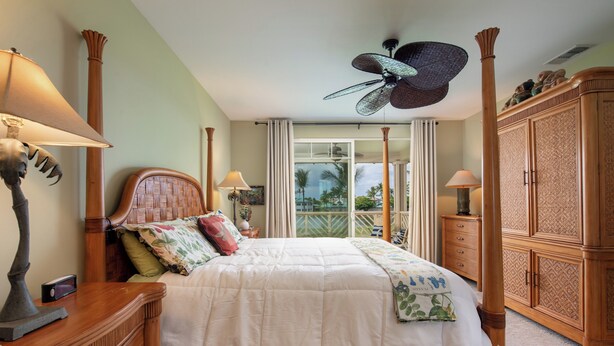 A bedroom with a four-poster bed, a ceiling fan, and a view of the outdoors through a large window. - Hilton Pool Pass for 2026!  Lake Views.  M2 Waikoloa Fairway Villas (Waikoloa Beach Resort)