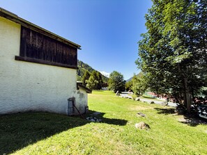 Una proprietà rurale con un edificio bianco, un prato e un albero.