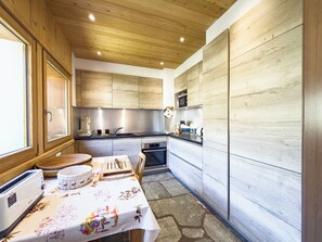 Una cucina moderna con mobili in legno, forno a microonde integrato e zona pranzo con tavolo apparecchiato per due persone.