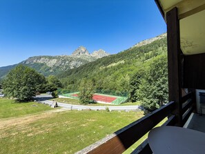 A mountain view with a tennis court and a wooden deck. - 90-square-meter chalet with a superb view (Chamonix-Mont-Blanc)