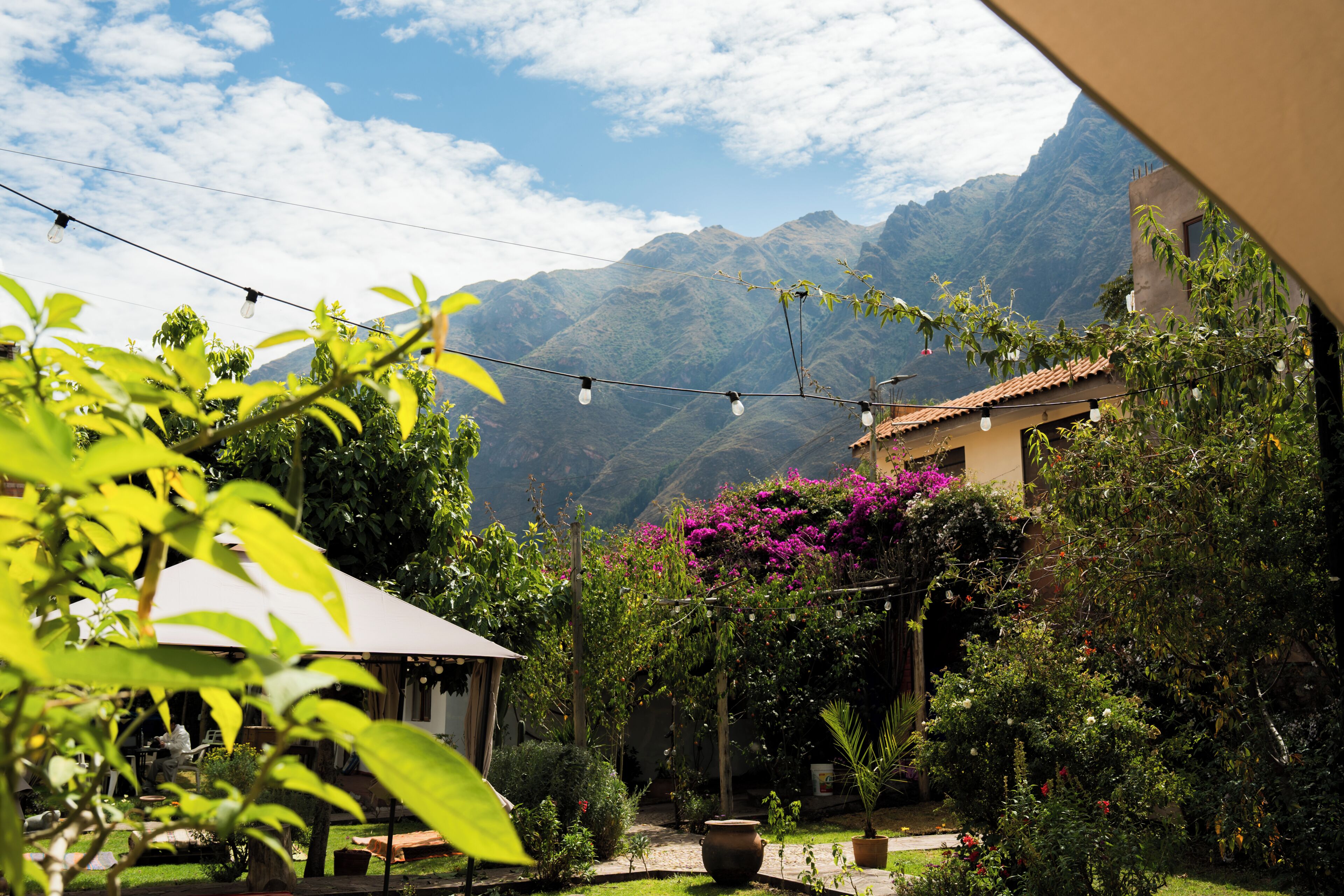 Un jardín con vistas a las montañas, un patio y luces colgantes.