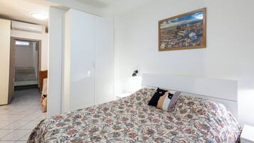 Un dormitorio con cama, un cuadro y una escalera que lleva a un nivel superior.