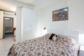 Un dormitorio con cama, un cuadro y una escalera que lleva a un nivel superior.