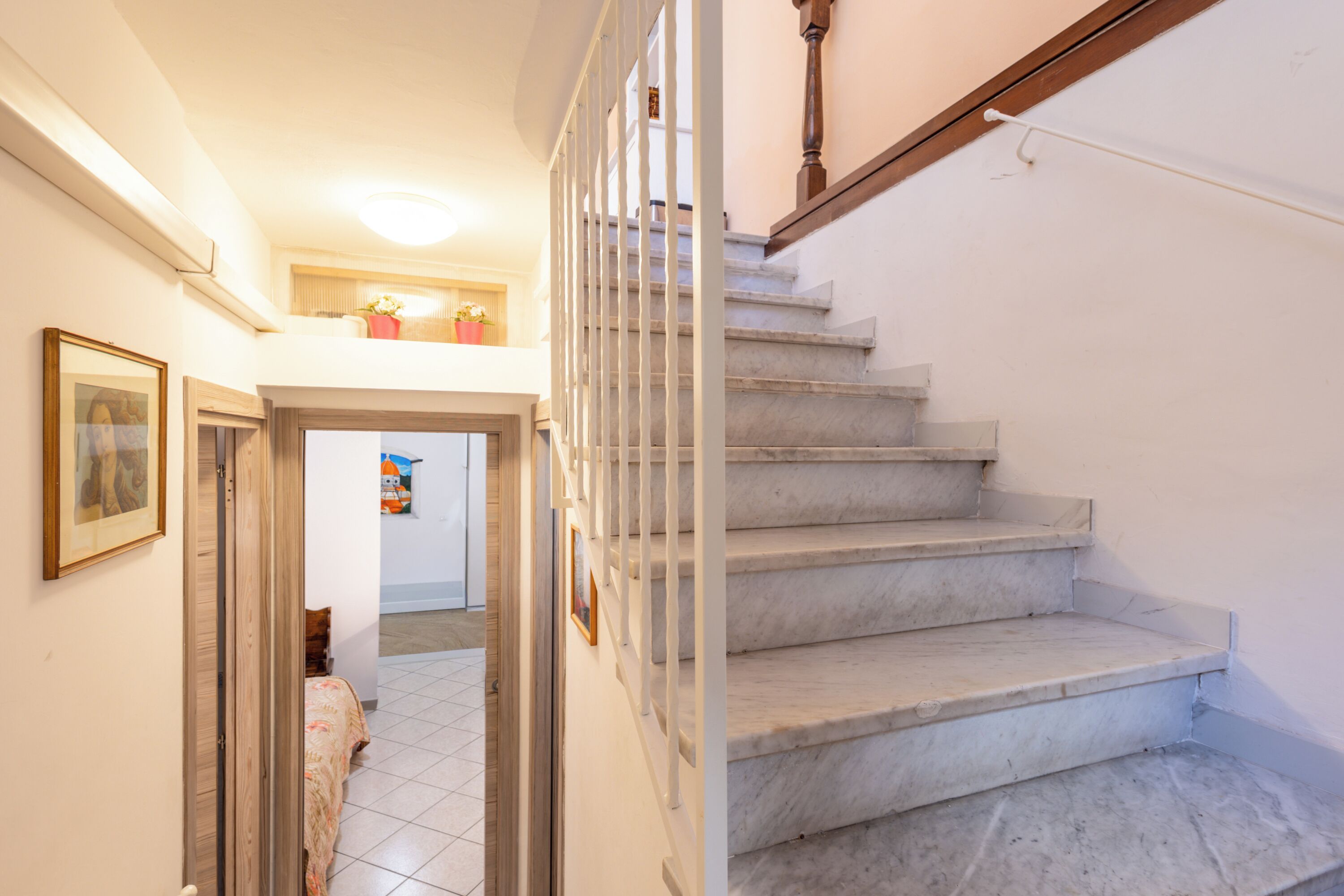 A staircase with marble steps leading to a landing.