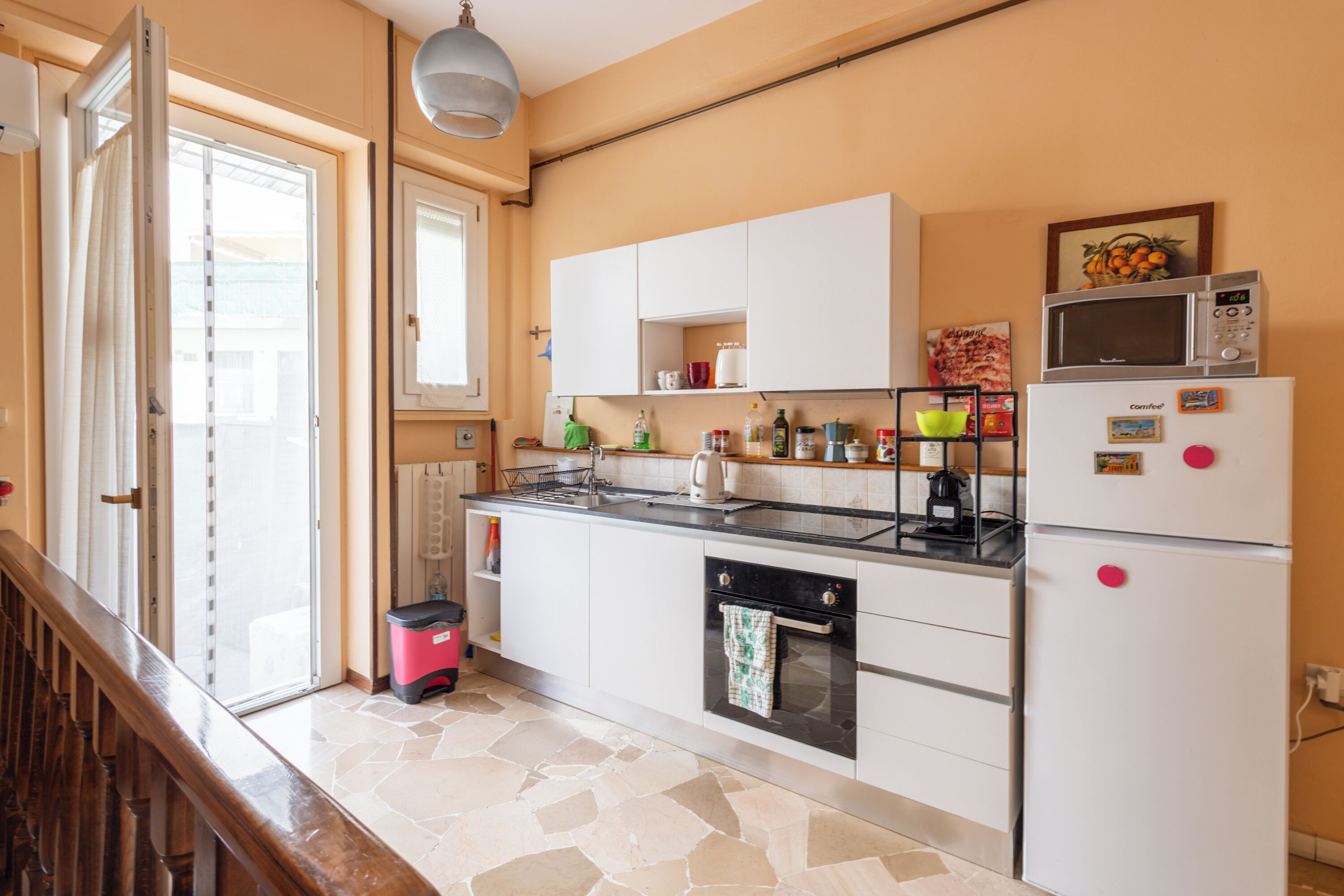 Una cocina equipada con estufa, horno, microondas y refrigerador.