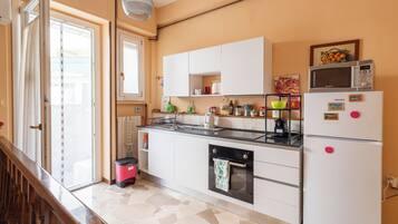 Una cocina equipada con estufa, horno, microondas y refrigerador.