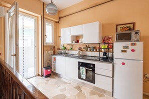 Una cocina equipada con estufa, horno, microondas y refrigerador.