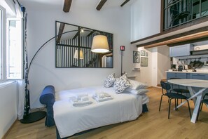 A modern bedroom with a bed, bedside lamps, a desk, and a dining area. - Trevi Little Palace #5 - 52 Steps - no elevator (Rome)