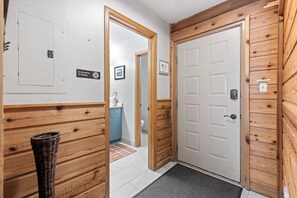 A hallway with wooden paneling, a white door, and a no smoking sign. - Walk to Main St & BreckConnect Gondola • Hot Tub & Views • Comfortably Sleeps 10 (Breckenridge)