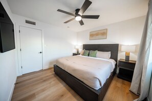 A modern bedroom with a bed, bedside lamps, a ceiling fan, and a door. - The Ultimate Scottsdale Hangout - 3 Bedroom Sleeps 10 (Scottsdale)
