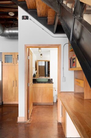 A modern kitchen with wooden cabinets, a marble countertop, and a visible sink.