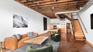 A modern interior with a wooden ceiling, a dining area, and a staircase.