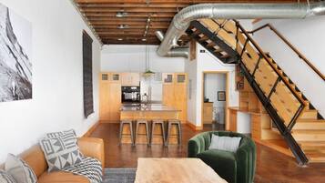 A modern interior with a kitchen, dining area, and a staircase.