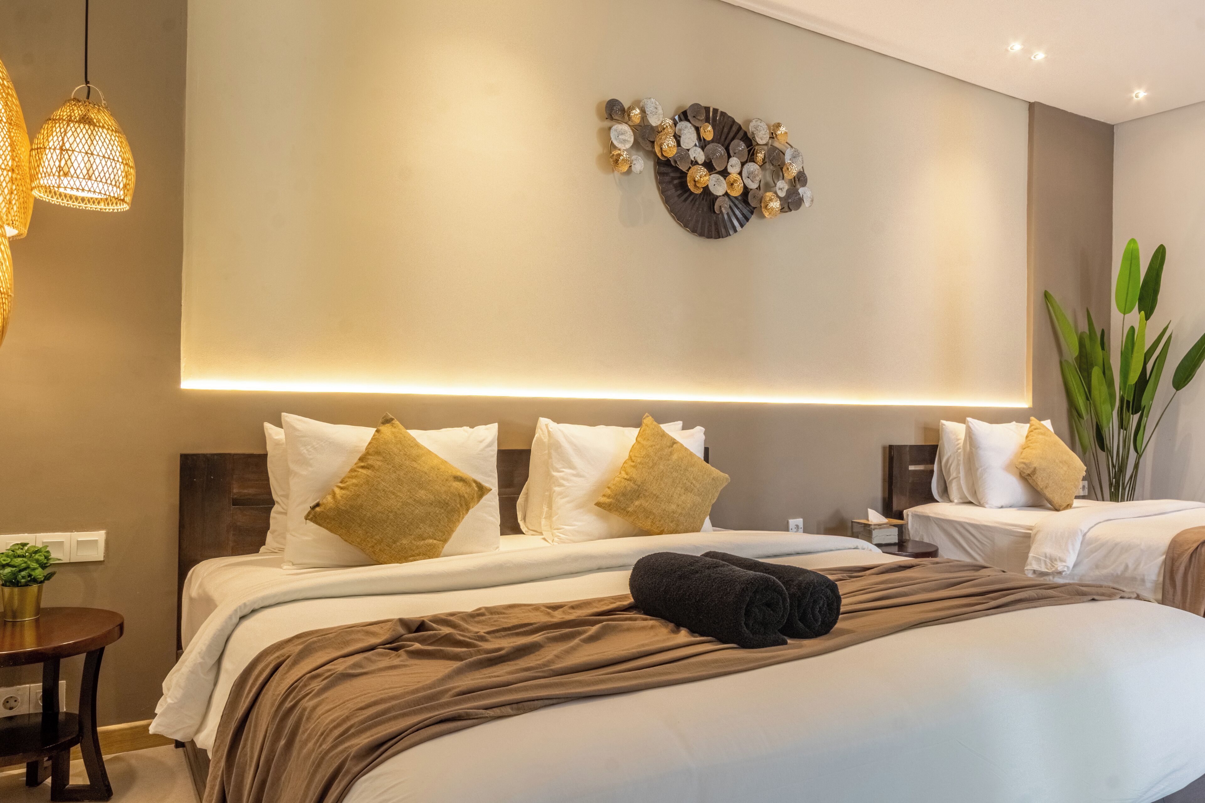 Een hotelkamer met een groot bed, een nachtkastje, een wandlamp en een decoratief wandobject.