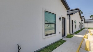 A row of modern, single-story buildings with large windows and a clean, white exterior. - Poolside Studio on Padre (#2) (South Padre Island)