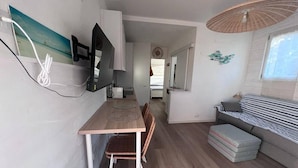 Ein kompakter Wohnbereich mit Essbereich, einer Couch und einem Deckenventilator.