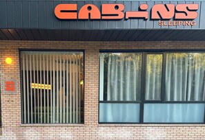A building with a sign reading 'CABINS SLEEPING' and a barred window.