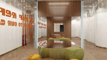 A modern interior with a curved seating area, wooden panel walls, and a glass partition with orange text.