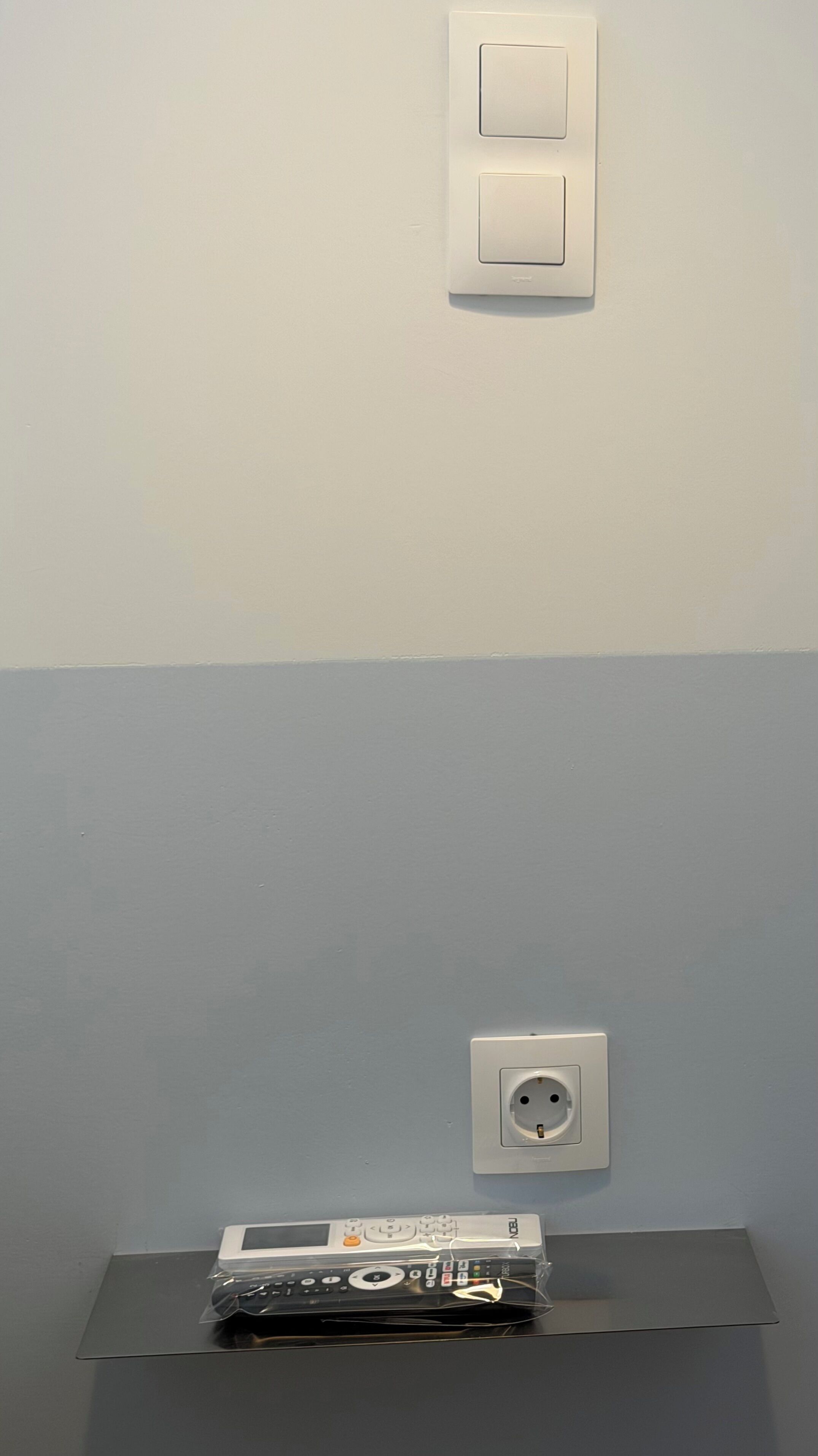 A wall with a light switch and an electrical outlet.