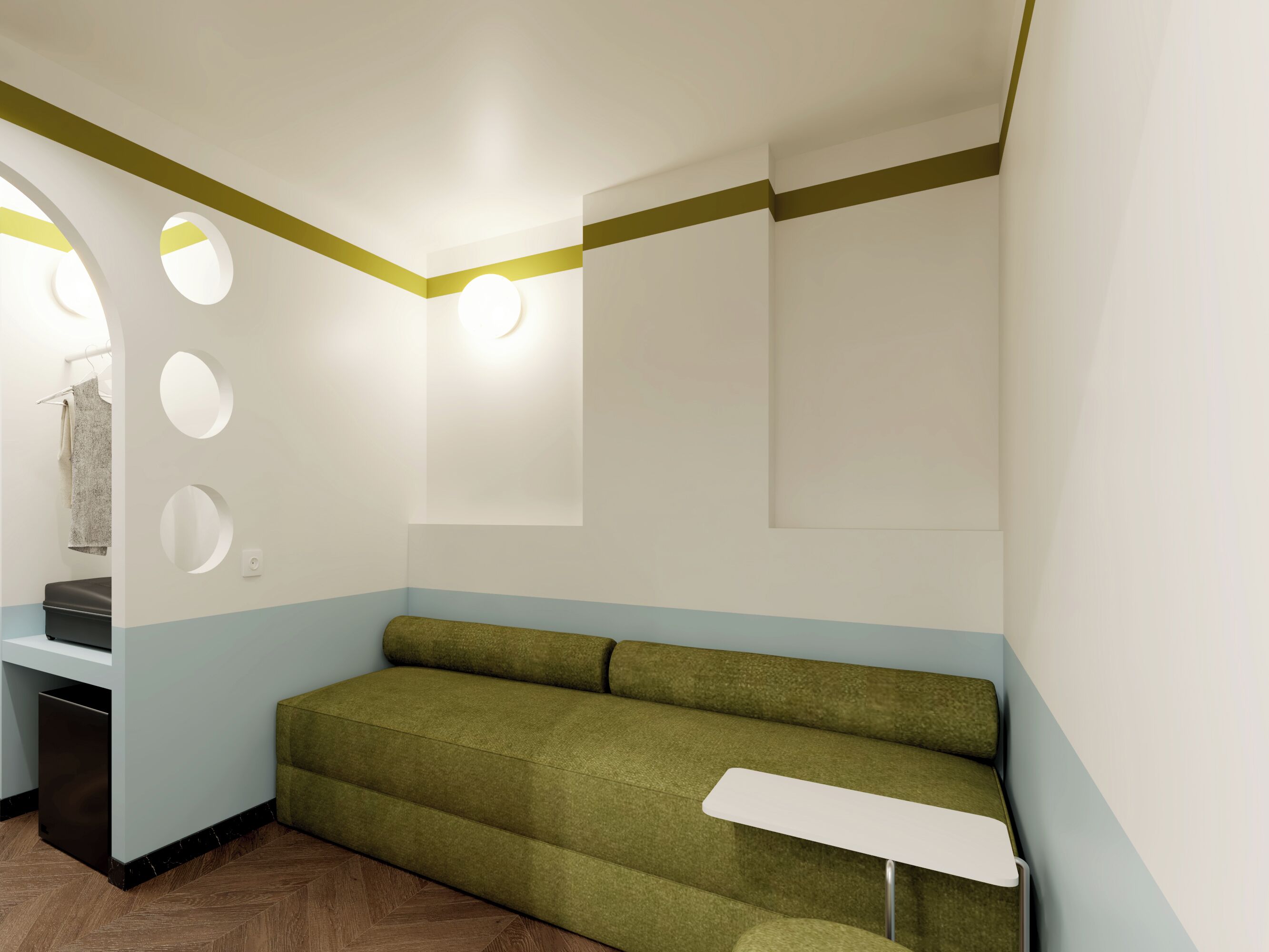 A room with a green sofa, a small table, and a mirror on the wall.