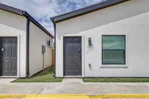 A row of modern, single-story buildings with front doors and windows, likely residential units. - Studio #3 | Island Time Studio w/Pool, near Beach (South Padre Island)