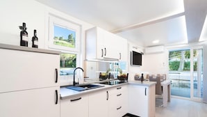 A modern kitchen with white cabinetry, a built-in stove, and a large window. - Exclusive Houseboat With hot tub (Piran)