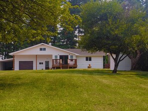 A single-story house with a front porch, a garage, and a well-maintained lawn. - Newly renovated home ,  River access,  minutes to Glacier Park (Columbia Falls)
