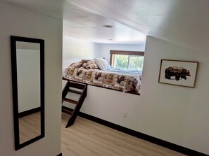 A bedroom with a bed, a ladder, a window, and a framed picture on the wall. - Newly renovated home ,  River access,  minutes to Glacier Park (Columbia Falls)