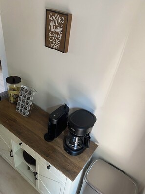 A kitchen counter with a coffee maker, a coffee pod holder, and a coffee grinder. - Newly renovated home ,  River access,  minutes to Glacier Park (Columbia Falls)