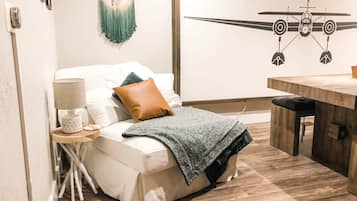 Une chambre à coucher avec un lit, une table de chevet, une lampe et un motif décoratif sur le mur.