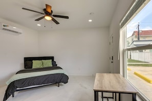 A bedroom with a bed, a ceiling fan, a window, and a table. - Modern South Padre Studio #4 - Blocks to Gulf/Pool - Apartment (South Padre Island)